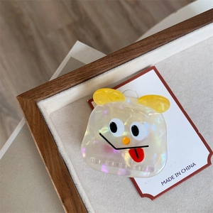 Macro shot of colorful acetate hair claw with cute cartoon monster face on display