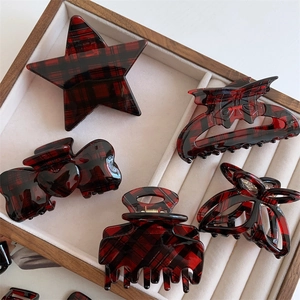 Set of various red and black plaid pattern hair claws displayed in a wooden gift box