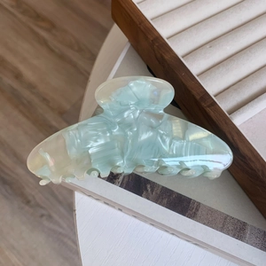 Detailed macro view of mint green marble texture on a large acetate hair claw clip