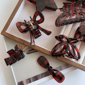 Detailed collection of red and black checkered acetate hair claws and clips on a tray
