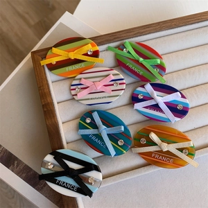7-piece set of striped acetate bow hair clips with rhinestones in a velvet tray