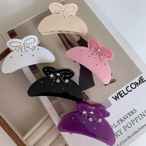 Gros plan détaillé des barrettes papillon en strass en cinq couleurs de pastel