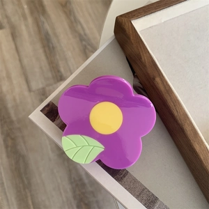 Detailed close-up of a medium purple floral hair claw with a glossy acrylic finish