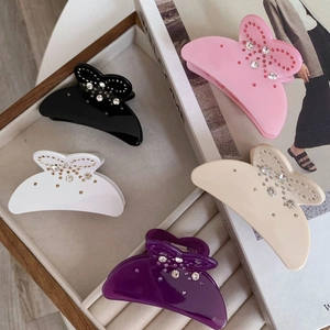 Pinces à cheveux papillon élégantes avec cristaux en cinq couleurs sur un magazine