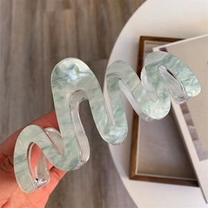 Détails de la grande pince à cheveux ondulée en acrylique avec texture marbrée verte et ressort