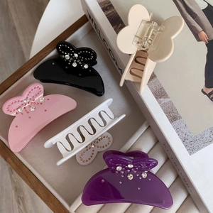 Détail de pinces à cheveux nœuds avec strass de diverses couleurs sur plateau bijoux