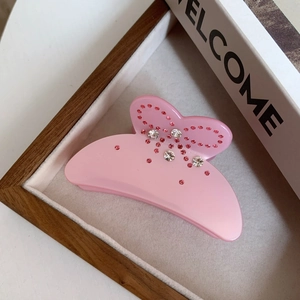 Pince à cheveux papillon rose élégante avec strass sur un plateau décoratif