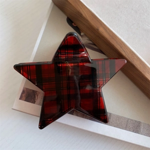 Detailed view of star-shaped hair claw featuring a classic red and black tartan plaid pattern