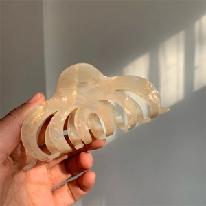 Detailed macro view of an ivory white octopus hair claw clip with a pearlescent finish