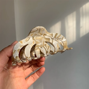 Detail of large acetate hair claw clip with marble texture for thick hair styling