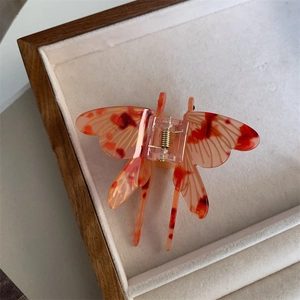 Detail of dragonfly hair claw clip with amber marble texture and gold metal spring