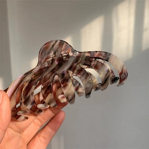 Detail view of large acetate claw clip showing vintage brown marble texture and strong grip teeth