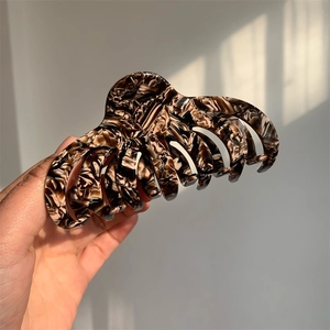 Detailed macro view of a large acetate claw clip with marble texture for thick hair