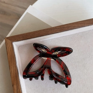 Detail of red plaid butterfly hair claw clip with smooth cellulose acetate texture