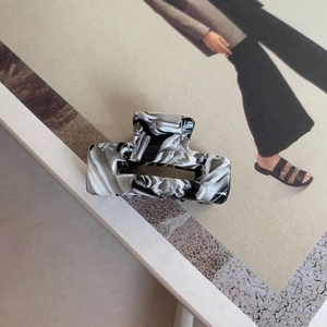 Detailed shot of rectangle hollow hair claw with black and white marble acetate patterns