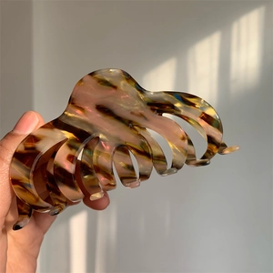 Detailed view of a large amber acetate hair claw clip with shell texture and strong grip