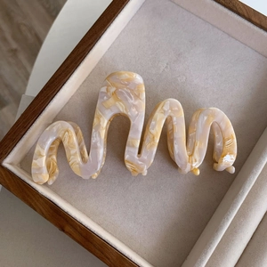 Detail showing the wavy cream marble pattern and acetate texture of this hair claw clip