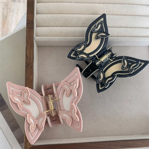 Elegant butterfly hair claw clips in black and pink resin with gold metal spring finish