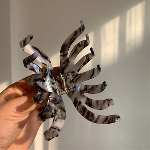 Detail showing marble texture butterfly claw clip with natural window light shadows