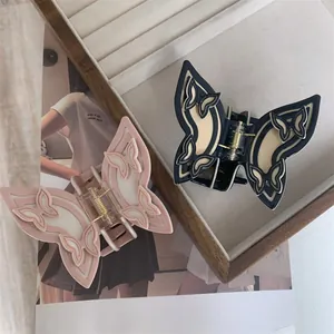 Detail of blue and pink butterfly hair claws with double-layered wings on wooden tray