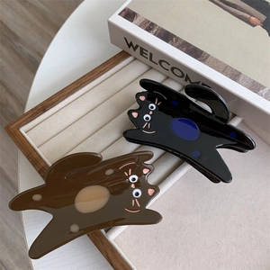 Detail of cute cartoon cat acetate hair claws in black and brown on a jewelry display