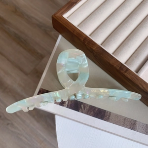 Detail of large acetate hair claw with iridescent pearlescent finish and secure teeth