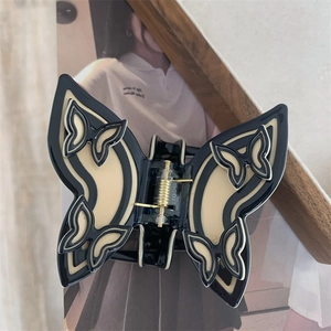 Artistic butterfly hair claw clip with black and cream hollow silhouette design