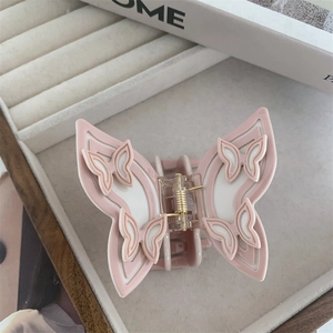 Detail of pink and white layered butterfly hair claw with golden metal spring