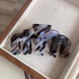 Détail de la pince à cheveux en acétate écaille de tortue avec des reflets bleus nacrés