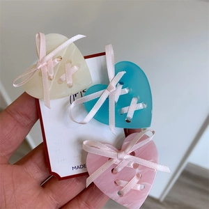 Lot de trois pinces à cheveux cœur en acétate avec nœuds en crème, bleu et rose