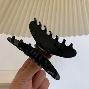 Détail macro d'une grande pince à cheveux nœud noir brillant avec ressort métallique