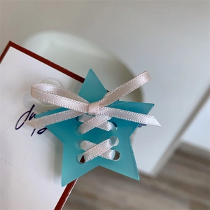 Détail d'une pince à cheveux étoile bleu clair avec nœud en satin rose style ballet