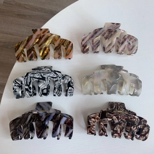 Lot de six grandes pinces à cheveux en acétate avec motifs marbre et écaille sur table blanche