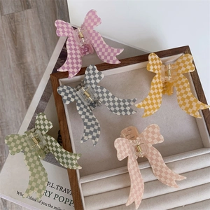 Set of five colorful checkerboard bow hair claws in pink, yellow, green, and grey