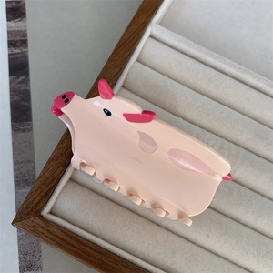 Close-up of a cute pink pig-shaped hair claw clip made of polished acrylic material