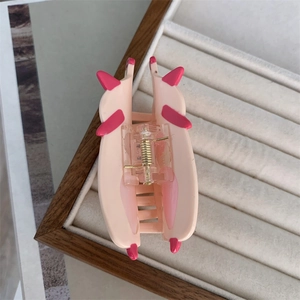 Detail showing the internal metal spring and pink animal-shaped hair claw clip