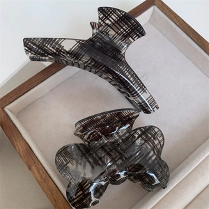 Two-piece set of black plaid textured hair claw clips in geometric and bow designs