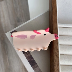 Detail of pink pig hair claw clip made of smooth acetate with creative animal design