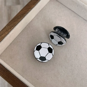 Vistas detalladas superior y lateral de pequeñas pinzas para el cabello con forma de balón de fútbol