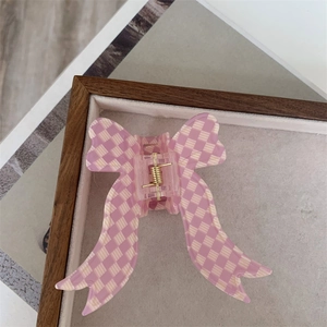 Detailed macro view of a sweet pink checkered bow hair claw clip made of resin