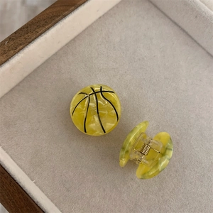 Detalle de la mini pinza para el pelo de baloncesto amarilla con rayas negras finas