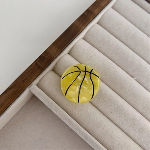 Detalle de pinza para el pelo de baloncesto amarillo con textura de mármol real