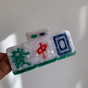 Close-up of acetic acid hair claw with traditional Chinese Mahjong tiles design and marble texture