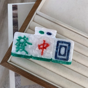 Macro detail of mahjong hair claw clip with marble texture and Chinese character design