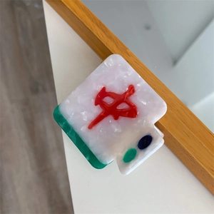 Macro shot of Mahjong red Zhong hair claw clip with colorful marble texture and sleek design