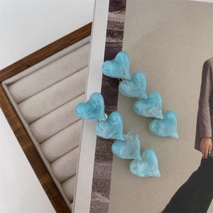 Detail of light blue marble textured heart hair clips on a lifestyle background