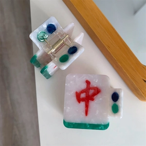 Detailed close-up of Mahjong themed hair claw clip with red character and marble texture