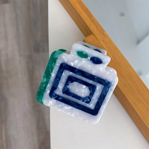 Detailed macro view of the rectangular acetate hair claw clip with colorful mosaic texture