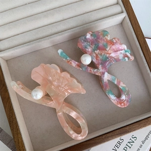 Detailed macro view of ginkgo leaf hair clips with marble texture and pearls