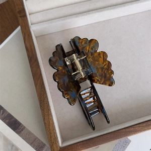 Detail of elegant butterfly hair claw clip with vintage acetate texture and metal spring